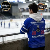 Toronto Marlies blue hockey hoodie with white hood, featuring AHL championship graphics and trophy on the back.!