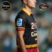 Black polo shirt featuring Super Rugby Pacific logo on sleeve and Chiefs rugby graphics in yellow, red, and white text.!