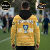 Yellow Hurricanes hoodie featuring a black hood and Super Rugby Pacific 2026 Champions graphics with a trophy illustration.!