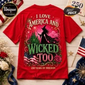 Red graphic t-shirt featuring a witch, a green castle, fireworks, American flag, and text I Love America And Wicked Too.!