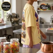Pale yellow oversized cotton t-shirt featuring a back print of Willy Wonka movie scenes, a purple top hat, and candy graphics.!