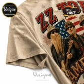 ZZ Top band t-shirt on cream fabric featuring band members, an American flag background, and bold red text.!