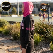 Woman wearing a black hoodie with a pink hood and Suncorp Super Netball champions graphics on the side.!