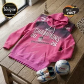 Pink Adelaide Thunderbirds netball champion hoodie with Suncorp Super Netball branding on a wooden table.!
