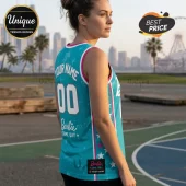 Customizable teal Barbie Game Day basketball jersey featuring pink trim, white star graphics, and Atlanta Dream branding.!