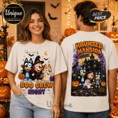 Bluey Boo Crew Halloween T-Shirt featuring cartoon dogs in costumes, a haunted mansion graphic, and pumpkins on cream fabric.