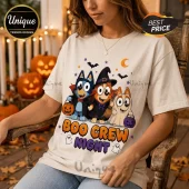 Bluey Boo Crew Halloween T-Shirt featuring cartoon dogs in costumes, bats, and jack-o'-lanterns on a cream cotton shirt.