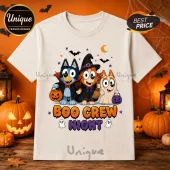 Bluey Boo Crew Halloween T-Shirt featuring cartoon dogs in costumes holding candy buckets on a beige cotton background.