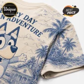 Bluey Playful Adventures Special Edition T-Shirt in beige with blue screen-printed palm trees and character illustration.