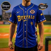 Blue baseball jersey with gold Buffalo text, scale pattern, dragon graphics, and a Nike swoosh logo on a baseball field.!