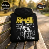 Black hoodie featuring Dizzee Rascal graphic with yellow bold text, graffiti art, and AU/NZ Tour 2026 print on wooden bench.!