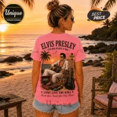 Pink t-shirt featuring Elvis Presley playing guitar on a beach, vintage record player, and song titles in a sunset graphic.!