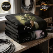 Stacked black cotton hoodies featuring an FKJ graphic of a person holding a branch, resting on a rustic wooden table.!