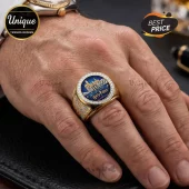Gold Harry Potter ring with a blue inlay featuring Hogwarts castle and text, surrounded by a band of small clear stones.!