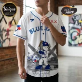 White Toronto Blue Jays baseball jersey featuring a KAWS-style character graphic with X eyes and a wooden bat.!