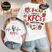 White t-shirt featuring Colonel Sanders graphics, KFC food items, and text reading I have a KFC's addiction.!