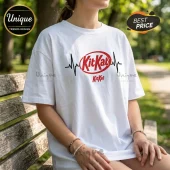 White short-sleeve cotton t-shirt featuring a red KitKat logo with a black EKG heartbeat line across the chest.!
