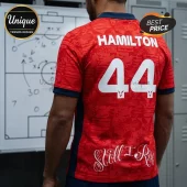Red Formula 1 jersey with Hamilton and number 44 in white, featuring Still I Rise text and dark blue collar details.!