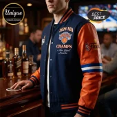 Man wearing a navy wool and orange leather 2026 NBA Knicks Champs varsity jacket with striped cuffs at a bar.!