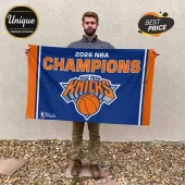 Man holding a blue and orange 2026 New York Knicks NBA Champions horizontal fabric wall flag with team logo.!