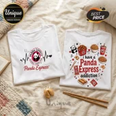 Two white cotton t-shirts featuring Panda Express logos, menu items like orange chicken and chow mein, and text on bed linen.!