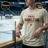 PWHL Hamilton Est 2026 off-white t-shirt featuring burgundy and gold graphic text on a person leaning against rink glass.