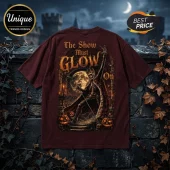 Maroon t-shirt featuring a skeletal king in a crown and cape with the text The Show Must GLOW On against a moon background.!