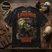 Rat Fink Harley-Davidson Haunt Hard T-Shirt featuring a green character riding a motorcycle in a haunted cemetery scene.