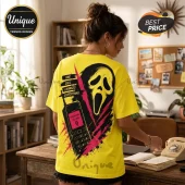 Bright yellow t-shirt featuring a Ghostface mask, a vintage cell phone, and the text One Call Changes Everything.!