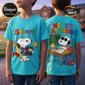 Cyan t-shirt featuring Snoopy as Superman on the front and Snoopy taking a test on the back with We Test At Dawn text.!