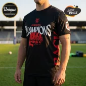 Black athletic t-shirt featuring a red fist, white Quadruple Champions text, and rugby team logo on a field background.!