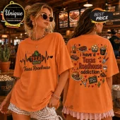 Orange cotton t-shirt featuring Texas Roadhouse graphics, steak dinner icons, and the text I have a Texas Roadhouse addiction.!