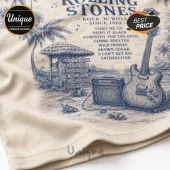 The Rolling Stones Premium Music Tour T-Shirt in beige with blue illustrations of a guitar, amplifier, and palm trees.