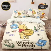 Winnie the Pooh bedding set featuring printed honey pots, bees, and flowers on a cream-colored fabric duvet and pillows.!