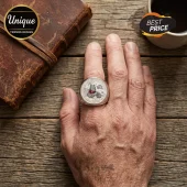 Winnie the Pooh 100th Anniversary Silver Ring featuring a circular engraved face worn on a finger over a wood background.