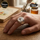 Winnie the Pooh 100th Anniversary silver ring on a finger with a vintage book background.