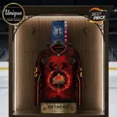Iron Flame Book x Colorado Avalanche Red Hockey Jersey featuring dragon graphics and team logo on a display shelf.